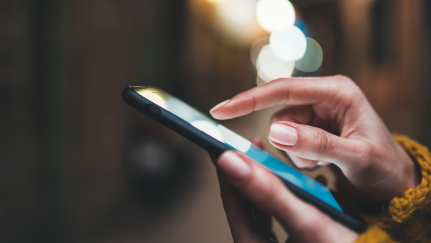 Hands holding a mobile phone.