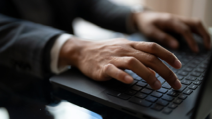 Hands on a laptop keyboard