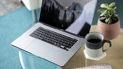Open laptop next to a cup of coffee